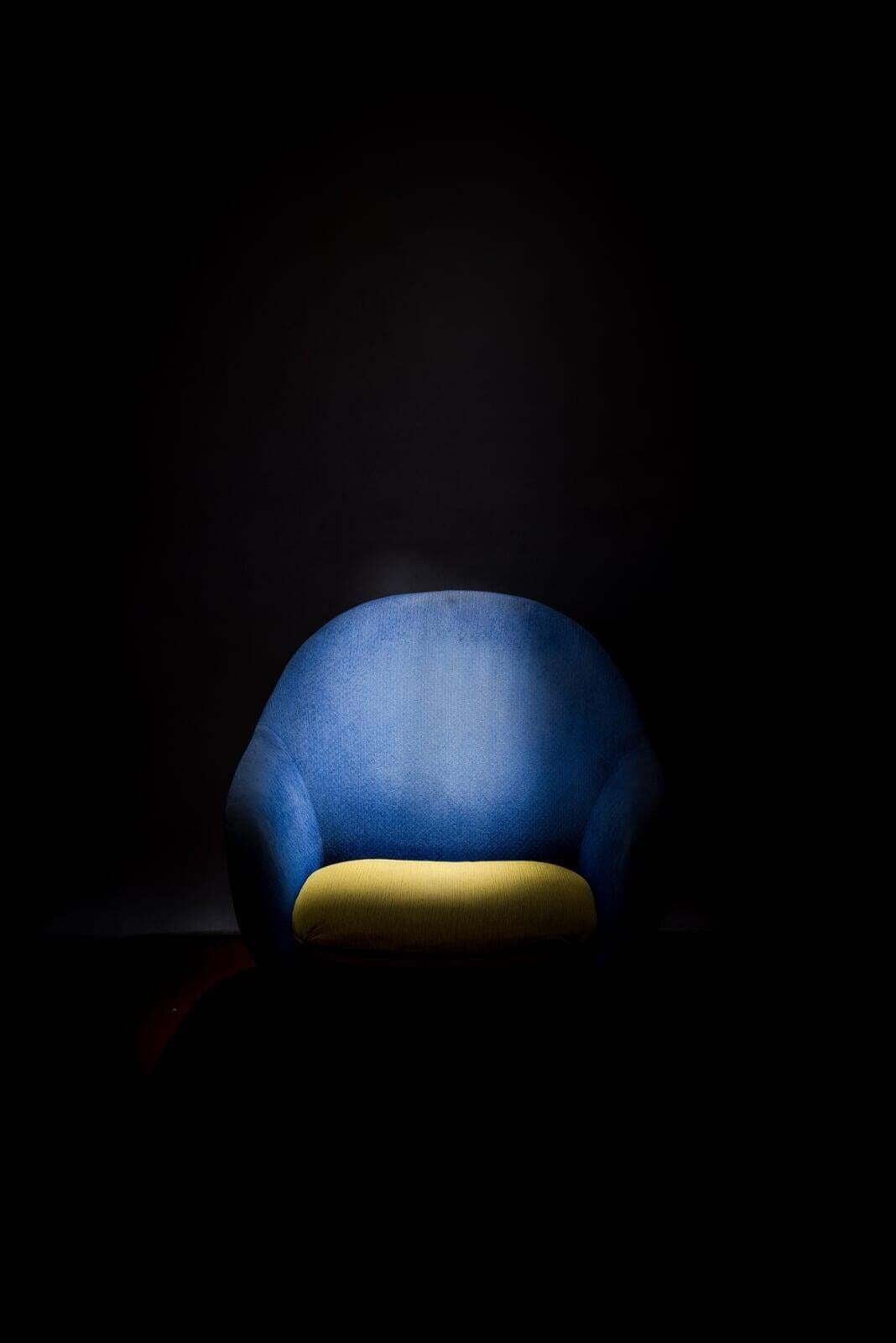 Spotlight on a blue chair with a yellow seat