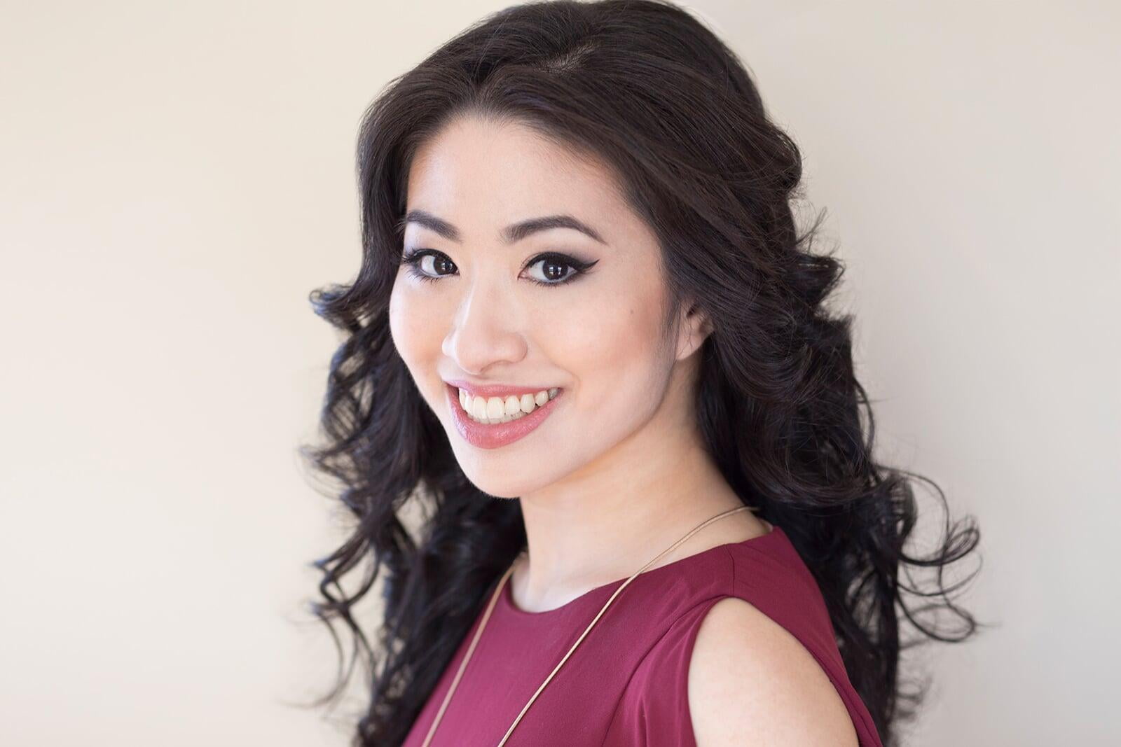 Headshot of Stephanie Ko, a smiling Chinese-Canadian woman wearing a red dress.